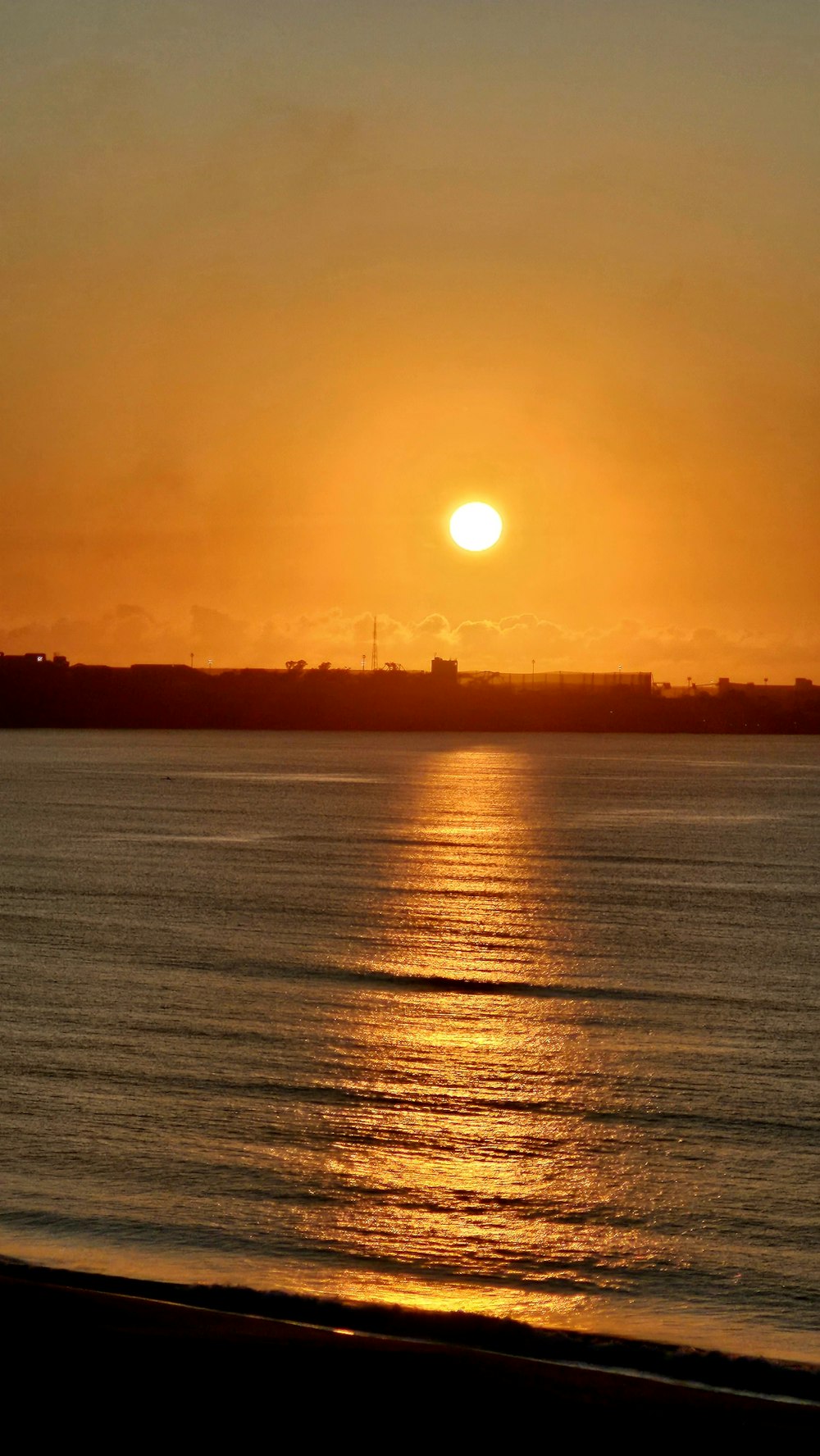 the sun is setting over a body of water