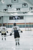 Two hockey players are on an ice rink, one with the name 'Spadafora' and number 17 on their jersey, and another with number 71. The score displayed on the scoreboard is Home 14, Guest 1, with the period indicated as 3 and the remaining time as 18:25.