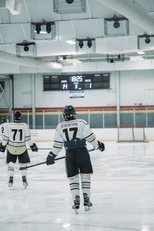Two hockey players are on an ice rink, one with the name 'Spadafora' and number 17 on their jersey, and another with number 71. The score displayed on the scoreboard is Home 14, Guest 1, with the period indicated as 3 and the remaining time as 18:25.