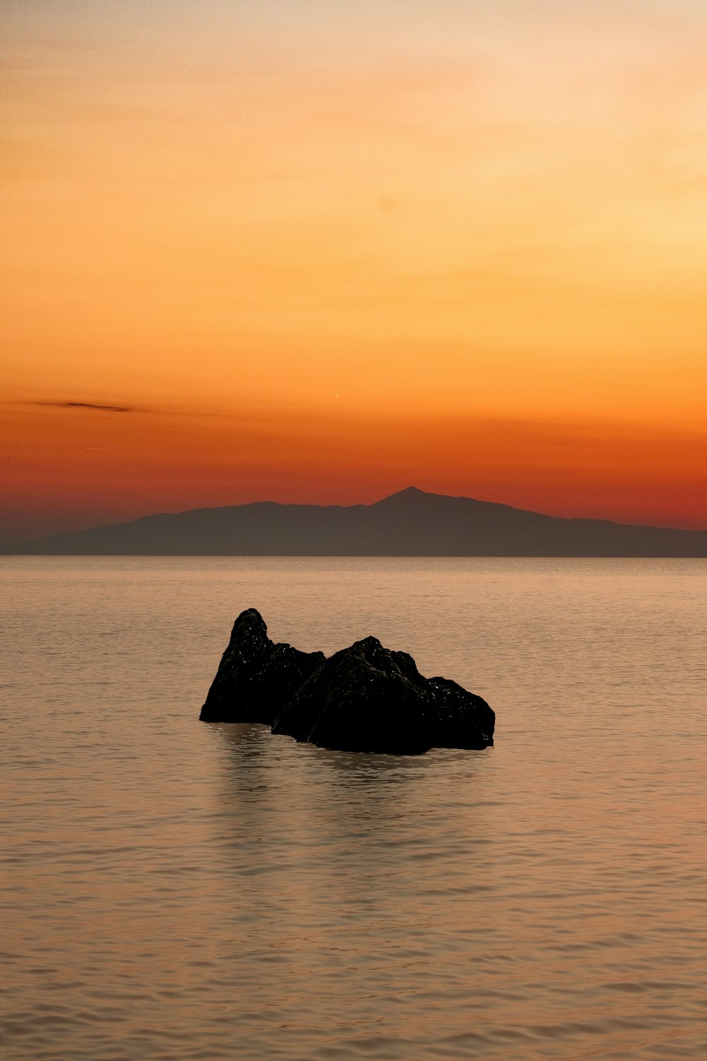 a large rock in the middle of a body of water