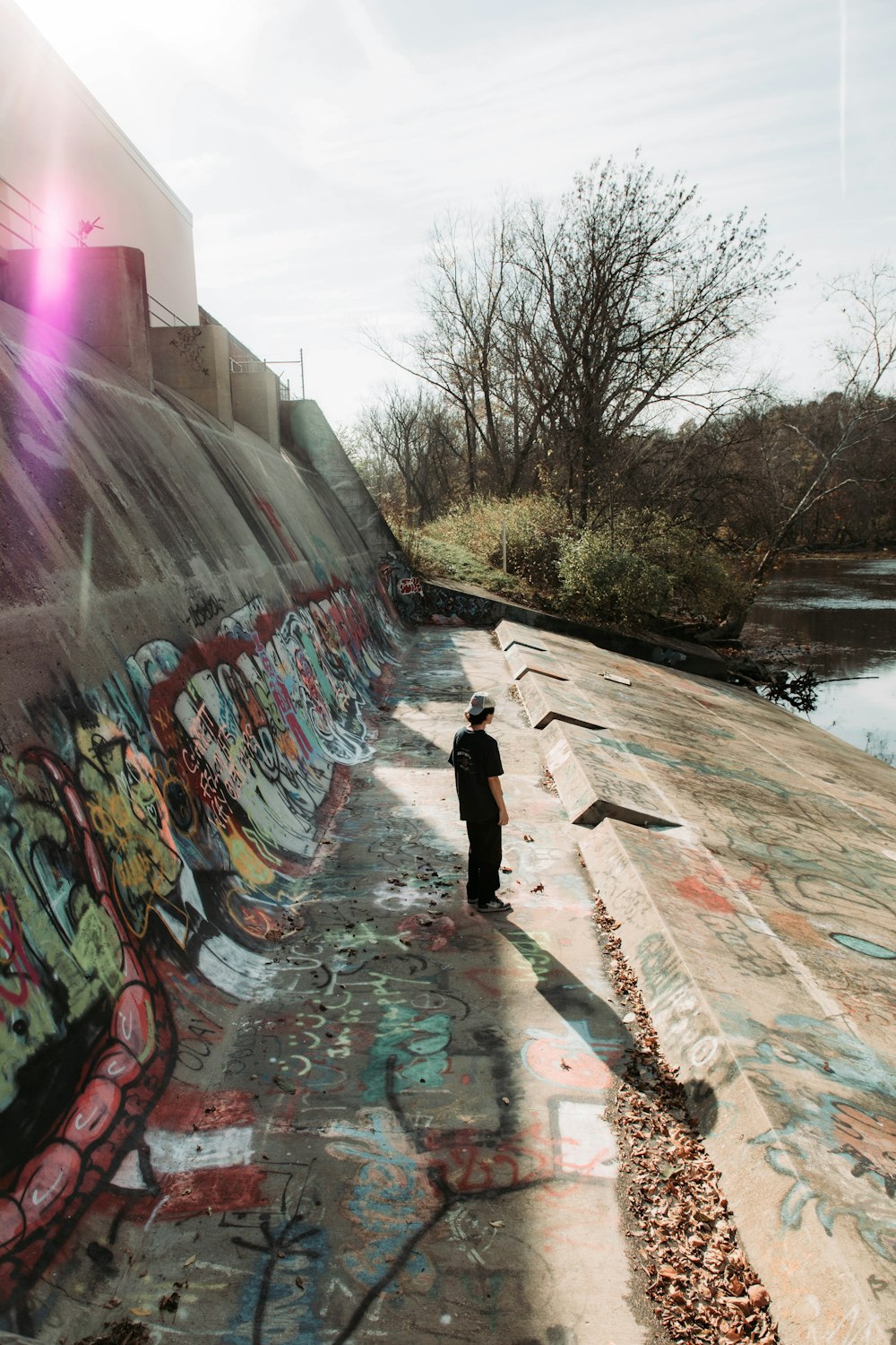 a person standing in front of a wall covered in graffiti