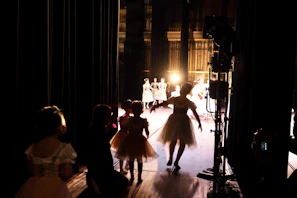 Backstage view showing actors preparing with makeup and costumes before going on stage.
