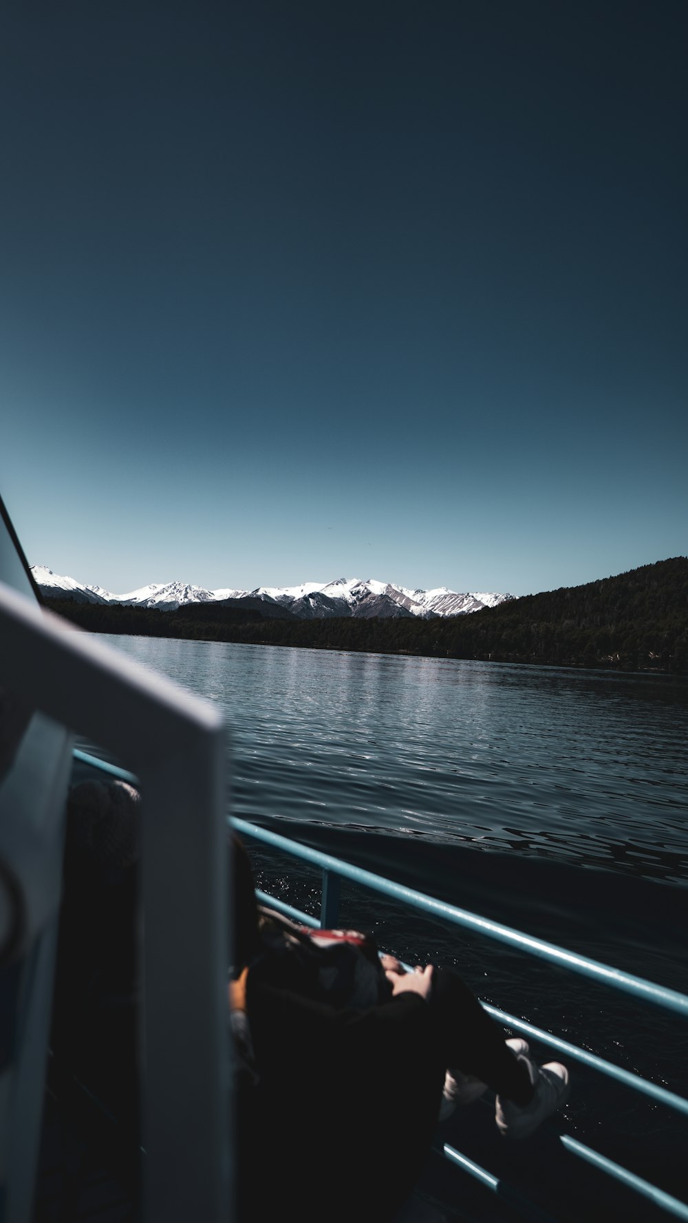 a boat traveling on a lake with mountains in the background
