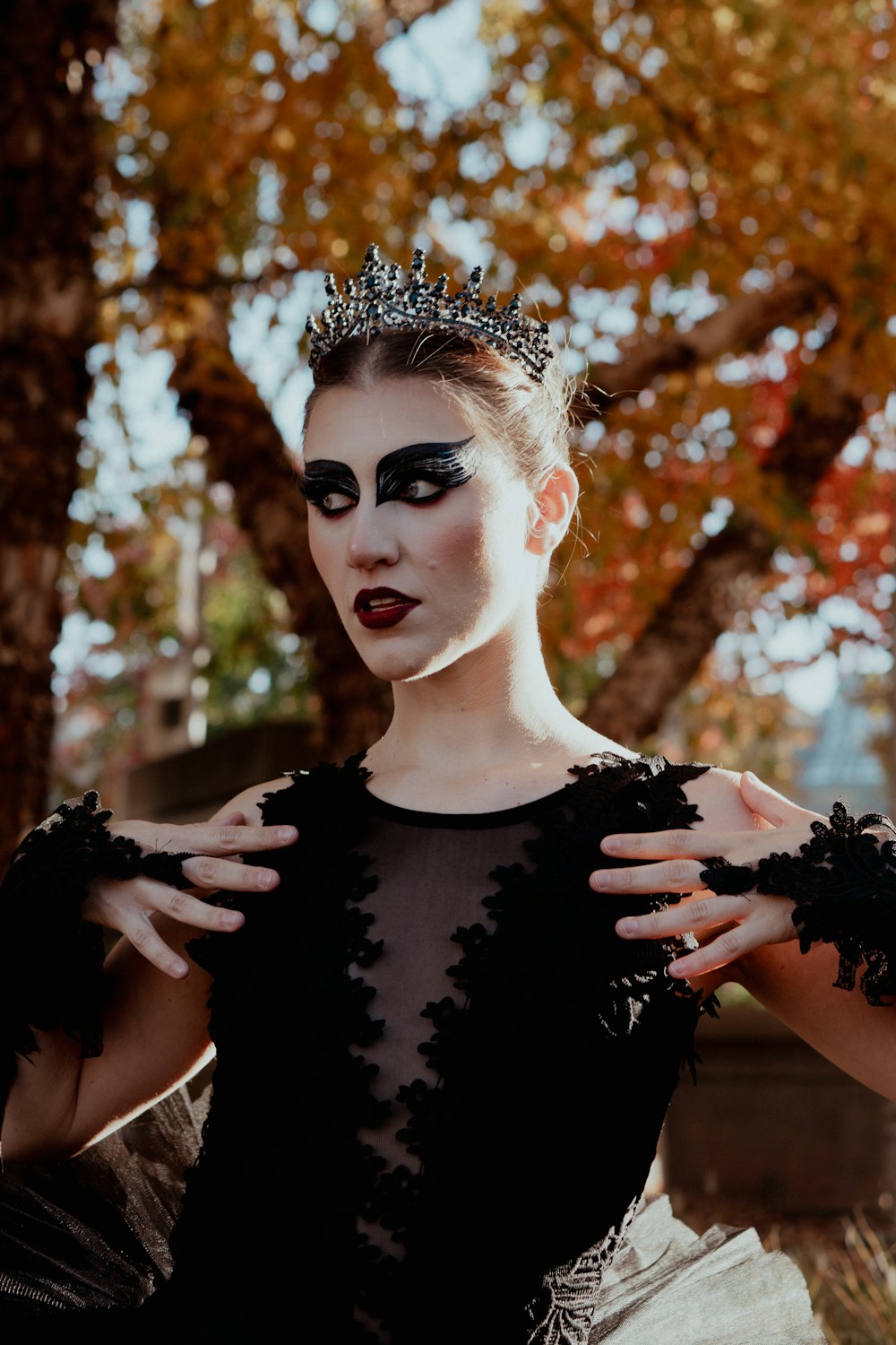 a woman in a black dress with a crown on her head