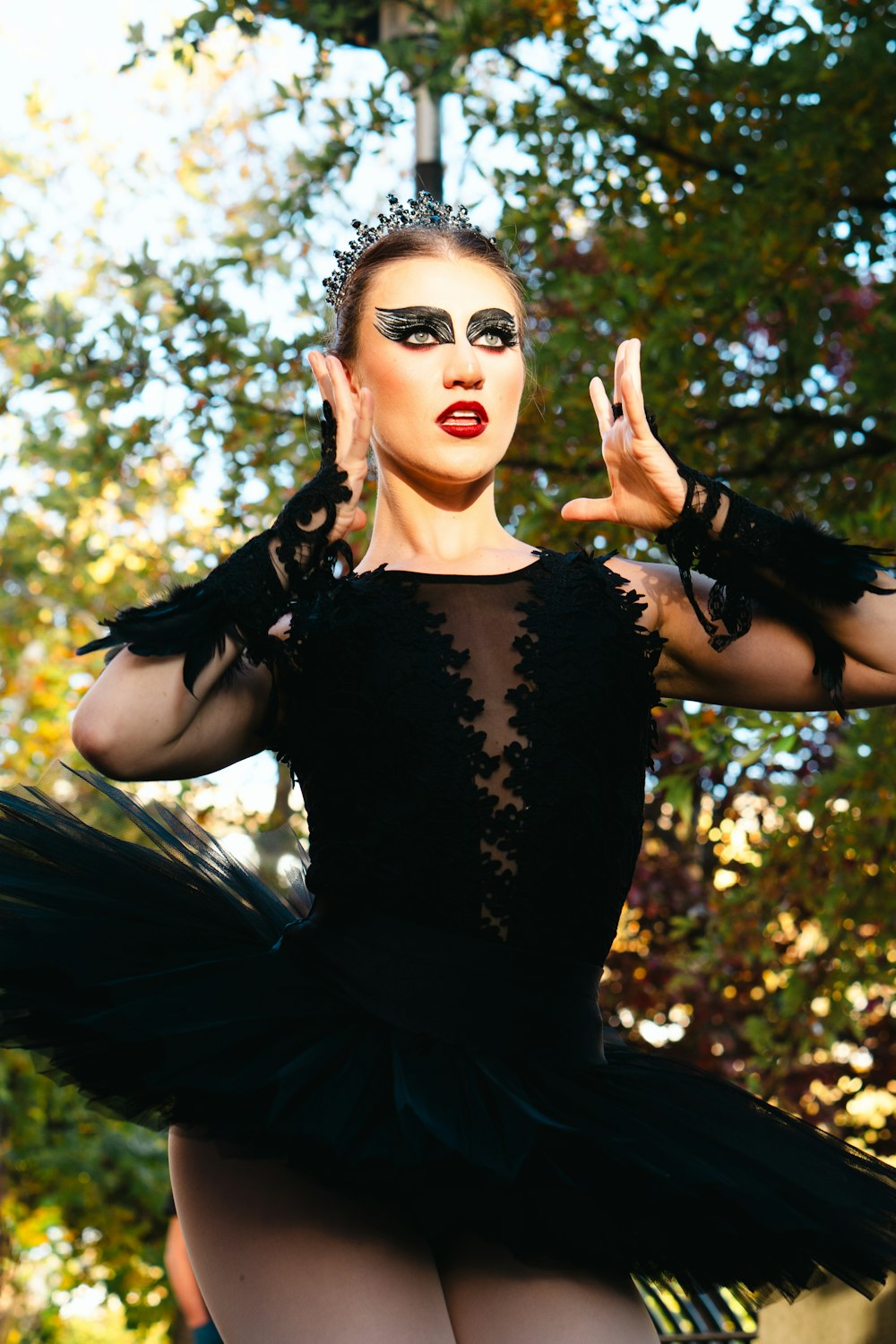 a woman wearing a black dress and a mask