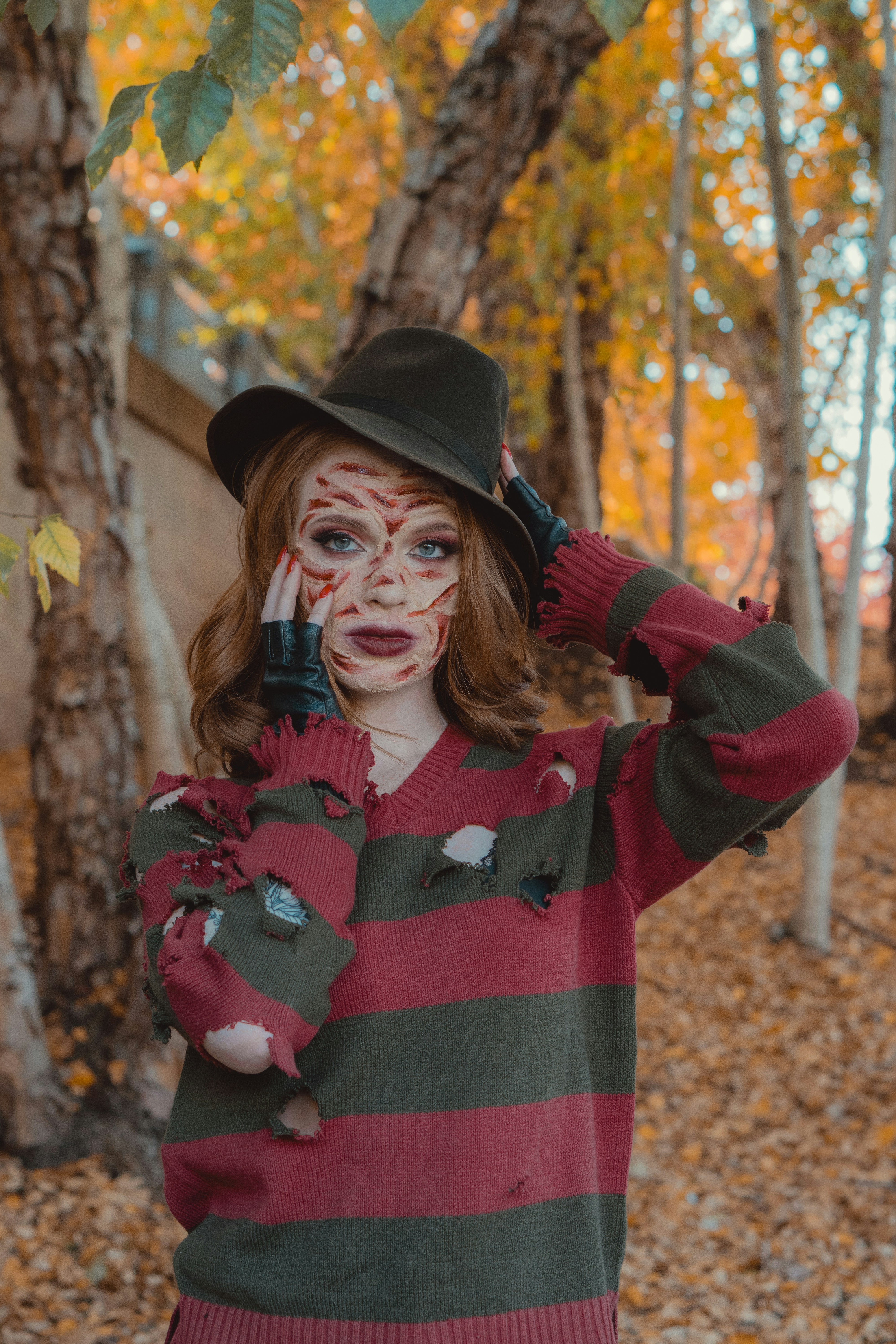 a woman with face paint and a hat on