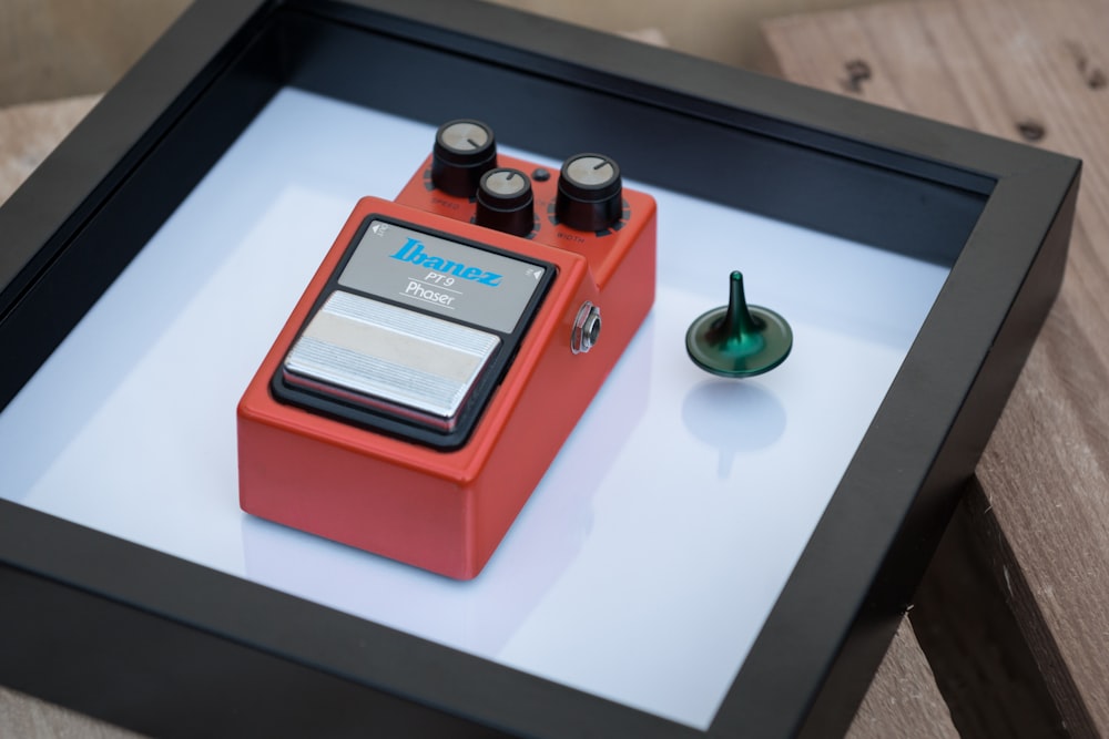 a red pedal guitar pedal sitting on top of a table