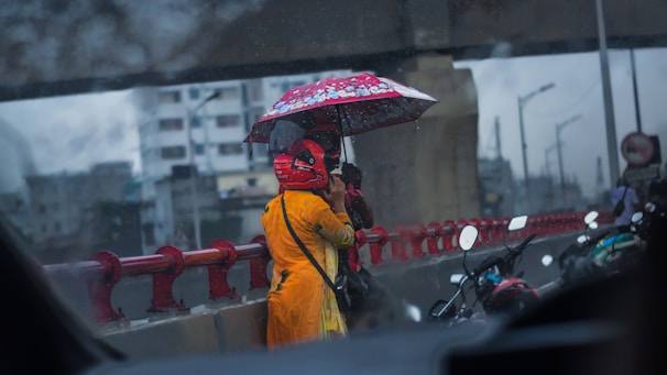 a woman in a yellow raincoat holding an umbrella
