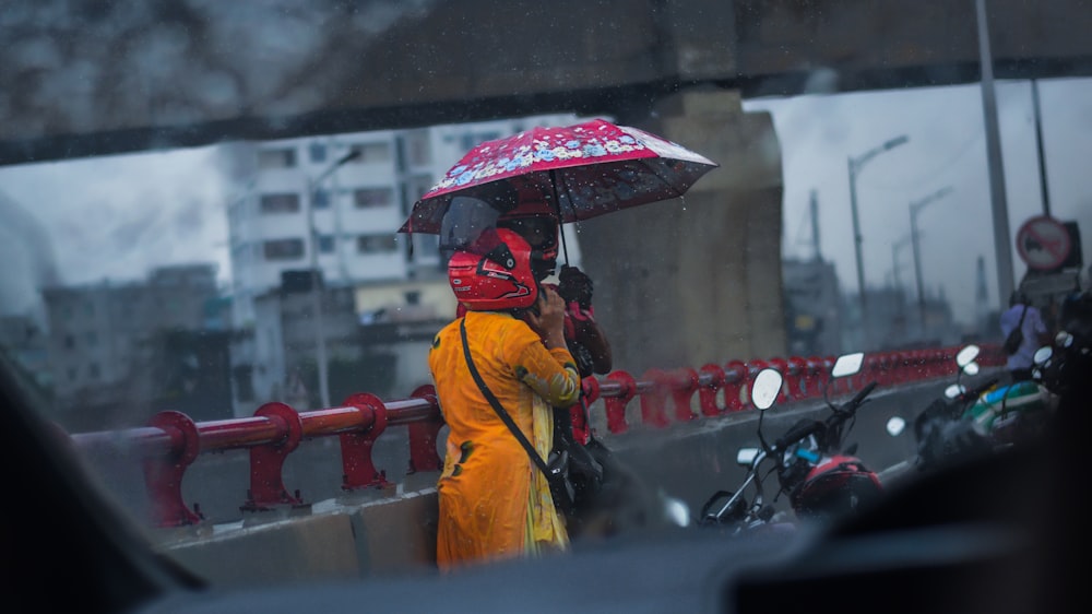 a woman in a yellow raincoat holding an umbrella