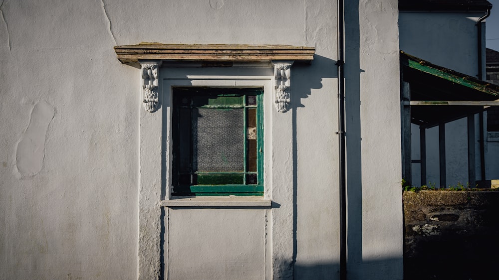 a white building with a green door and window