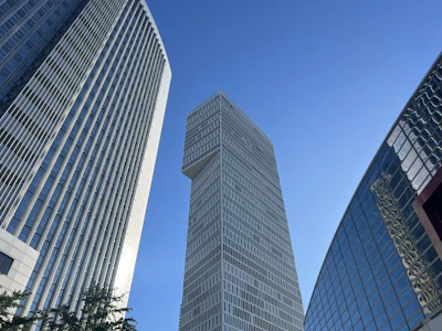 Modern commercial building exterior with glass facade under clear sky.