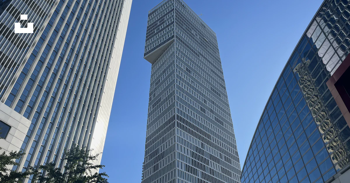 A very tall building towering over other tall buildings photo – Free ...
