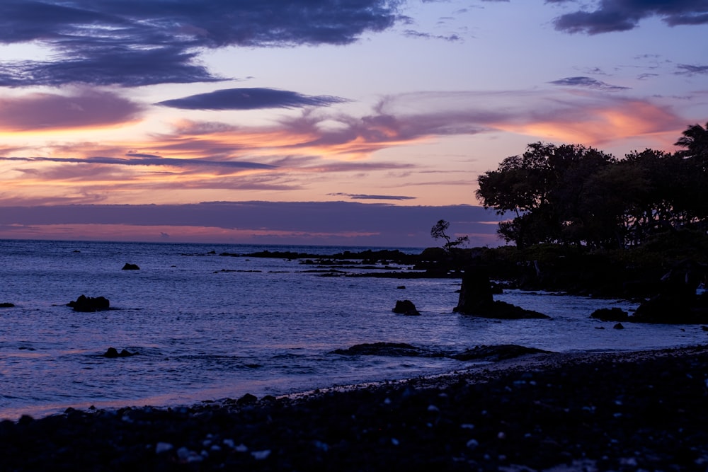 a beautiful sunset over the ocean with clouds