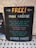 A humorous chalkboard sign titled 'FREE! MAN CRÉCHE' offers to look after men while their companions shop in peace. It humorously suggests not to forget their pocket money for food and drinks and ends with 'HAVE FUN!!!' in colorful lettering.