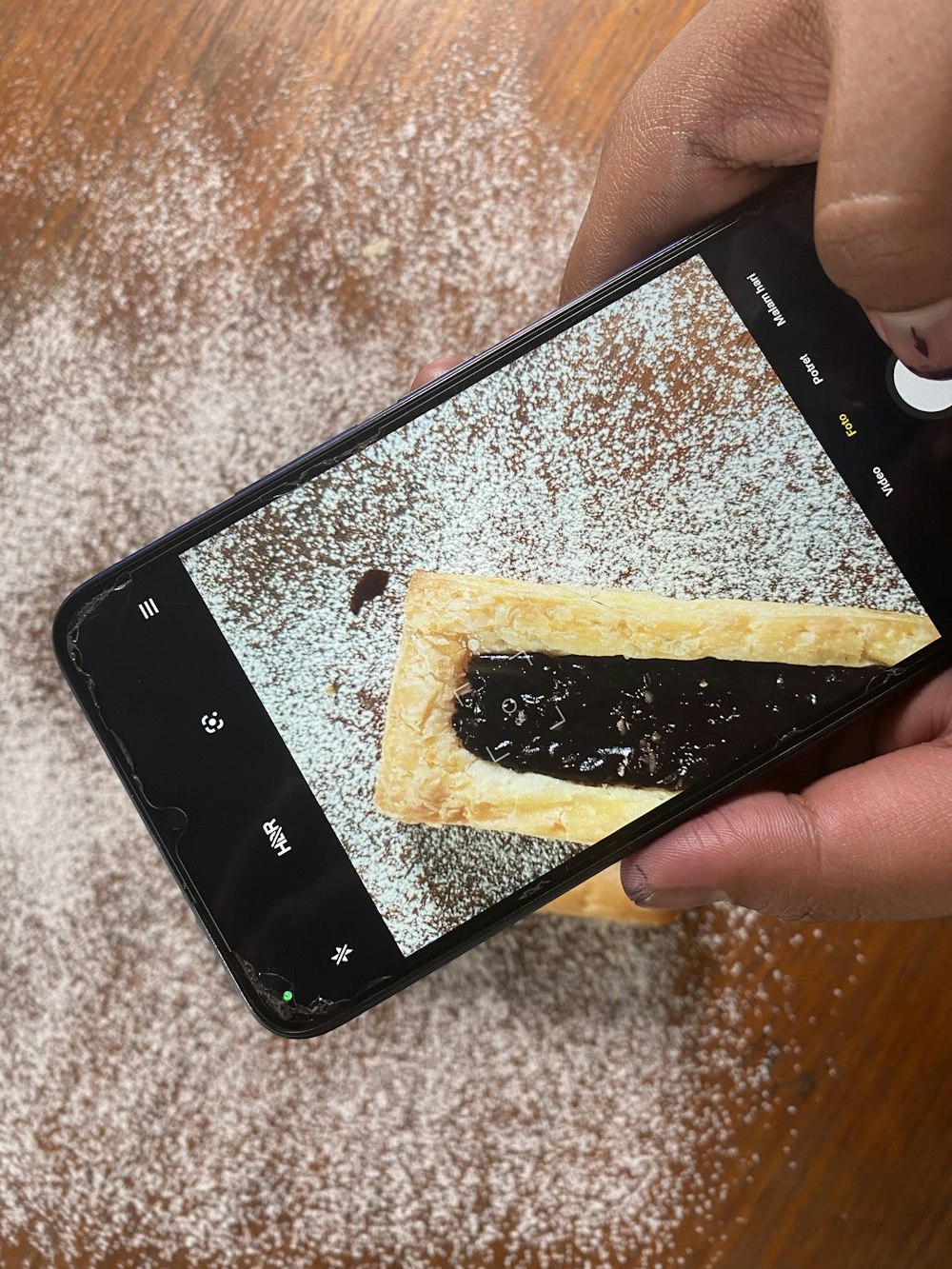 a person taking a picture of some food on a cell phone