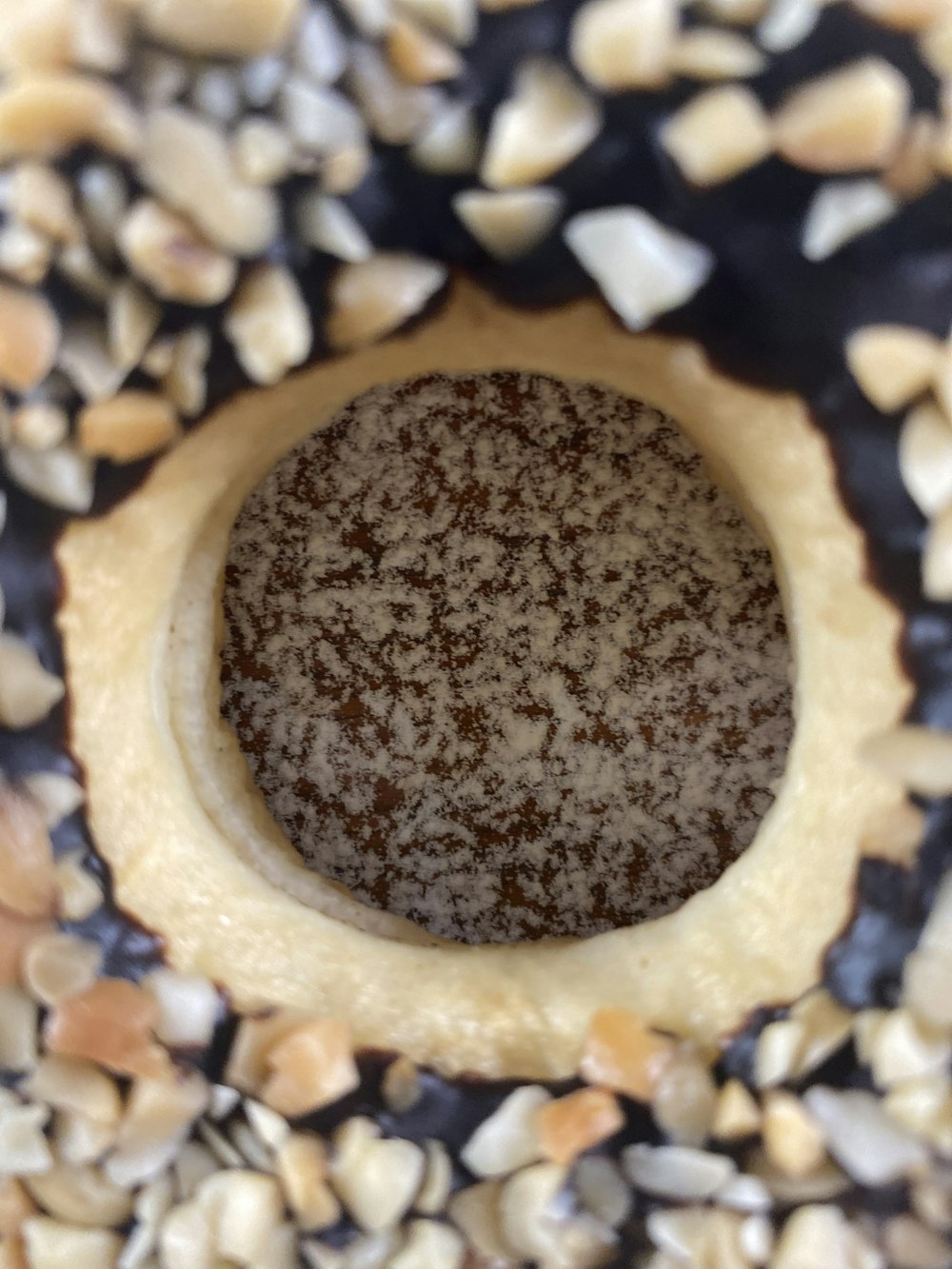 a close up of a doughnut with nuts on it