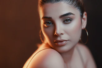 Close-up of a woman with soft, glowing engagement makeup and styled hair.