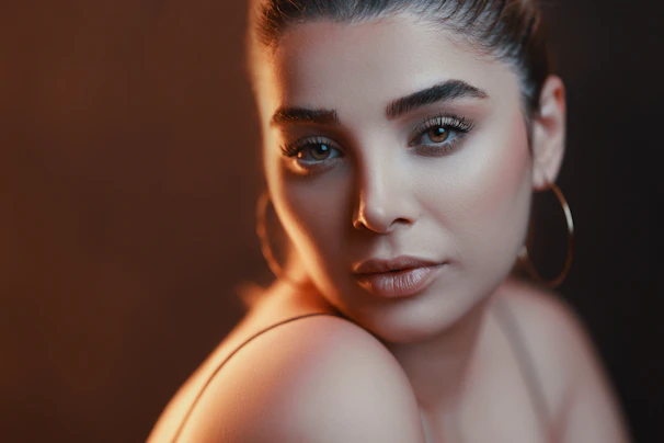 Elegant bridal makeup with natural tones highlighting the model's features in a cozy studio