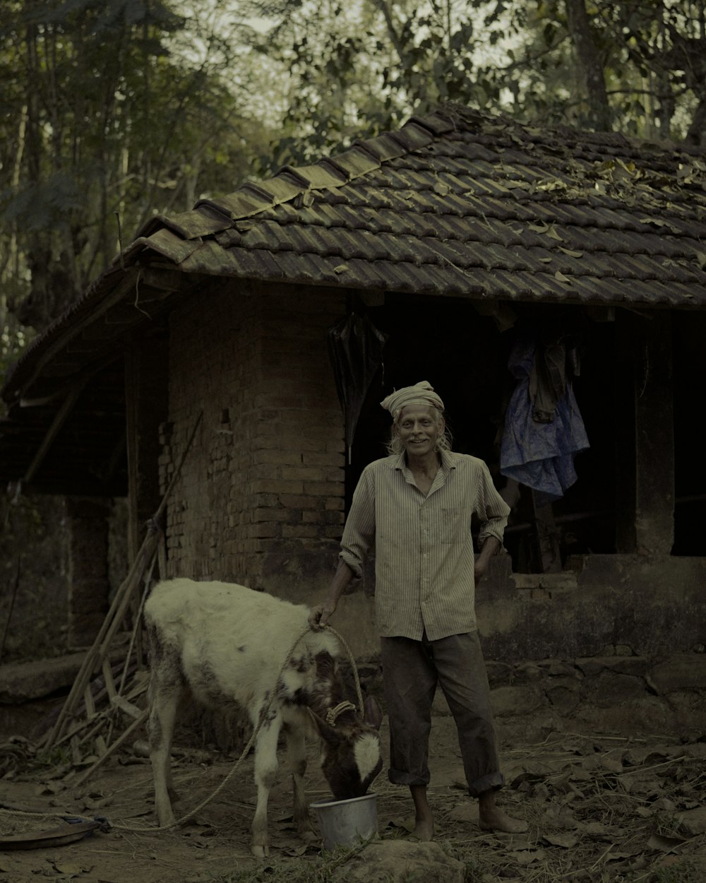 a man standing next to a cow in front of a building