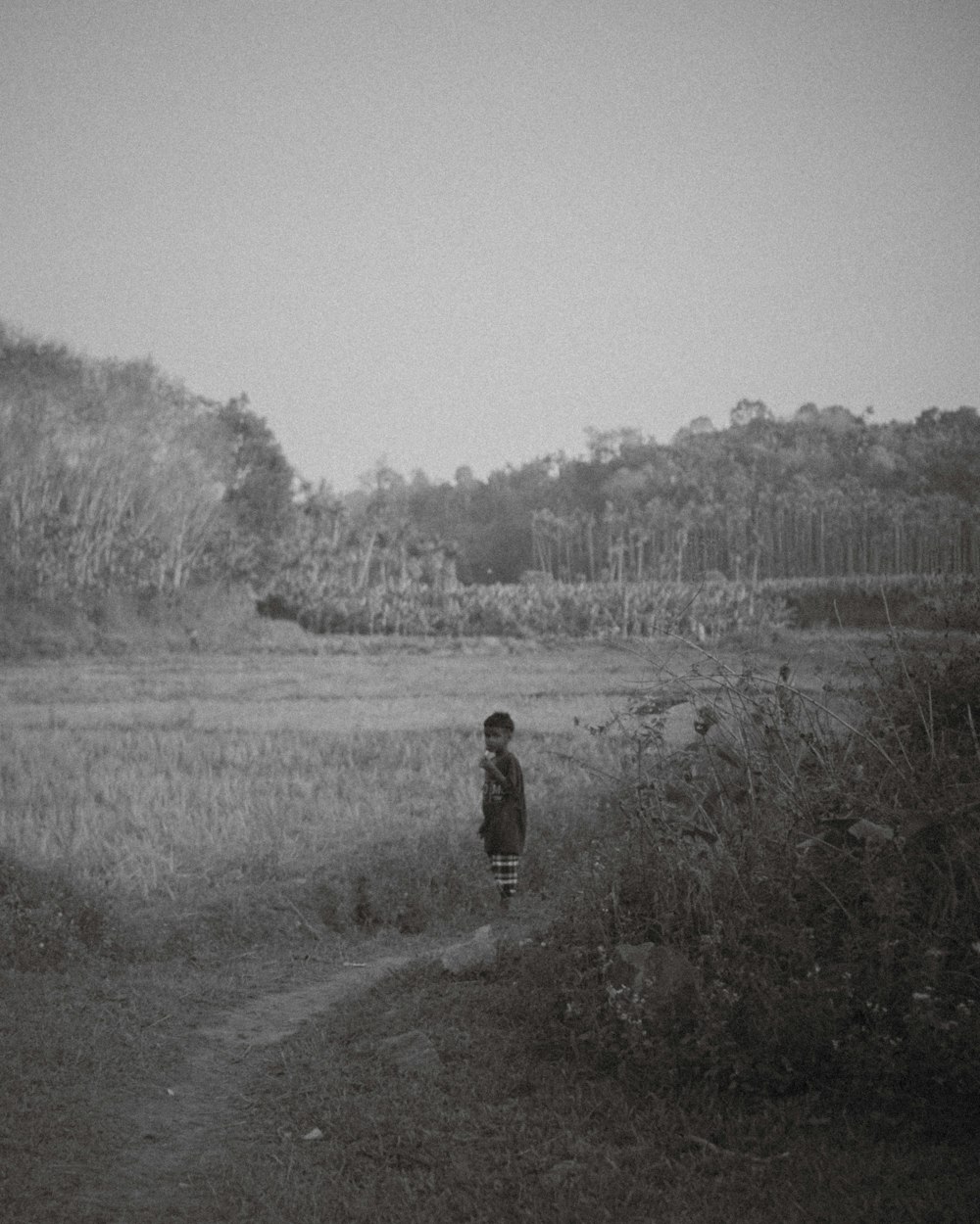 a black and white photo of a person in a field