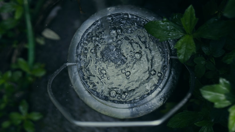 a metal bowl filled with water sitting on top of a table