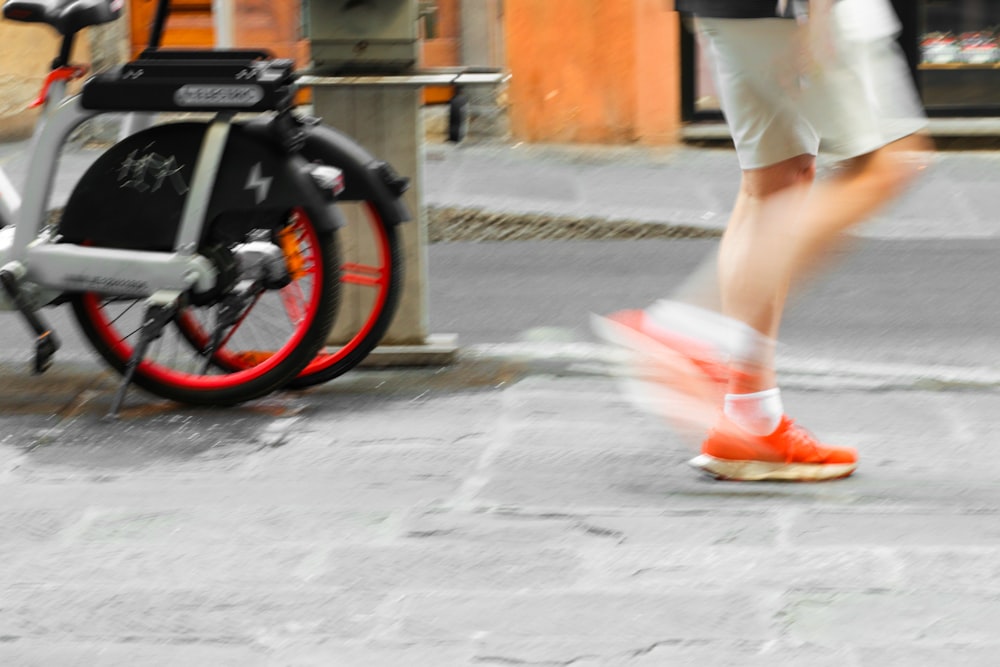 a person walking down a street next to a bike