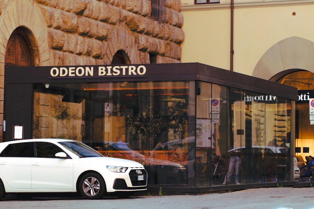 a white car parked in front of a building