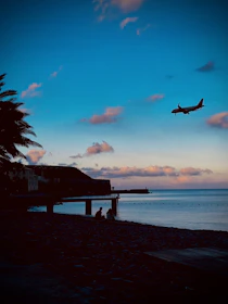 A scenic airplane flying over the coastline of Portugal at sunset.
