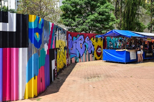 A vibrant artisan painting a colorful mural in an outdoor market setting.