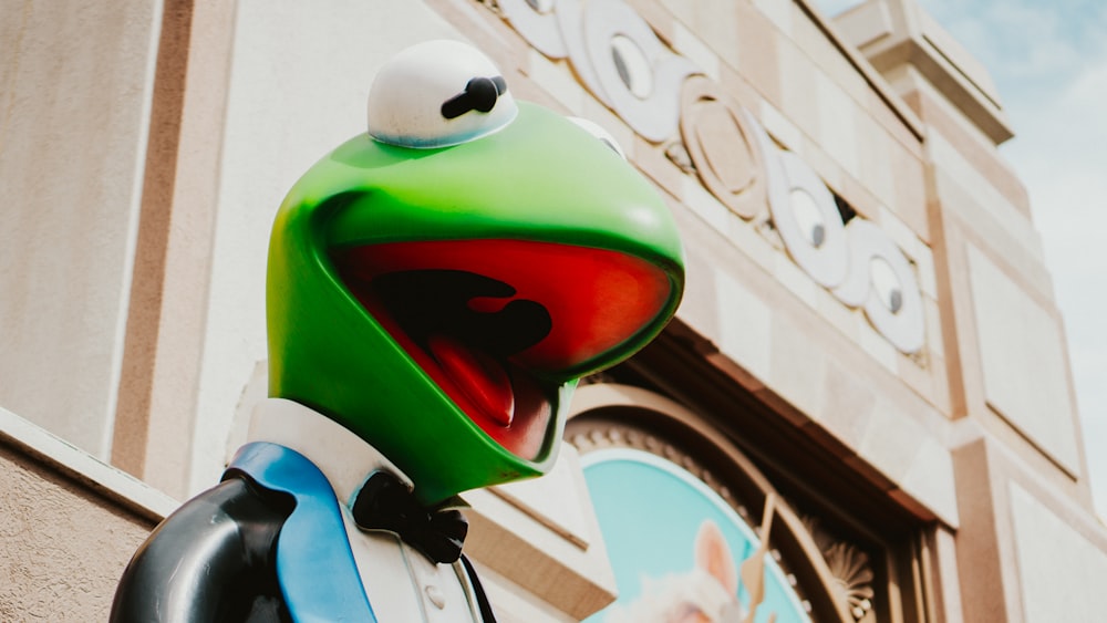 a close up of a statue of a frog on the side of a building