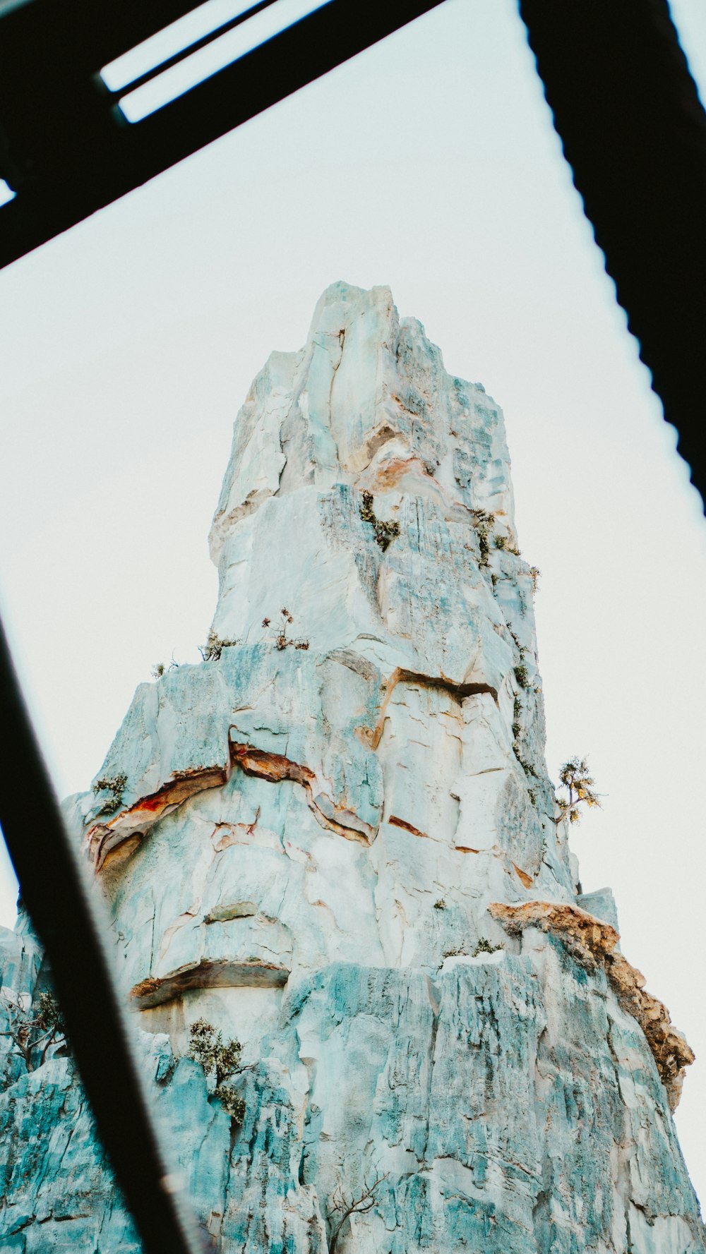 a very tall rock formation with a sky background