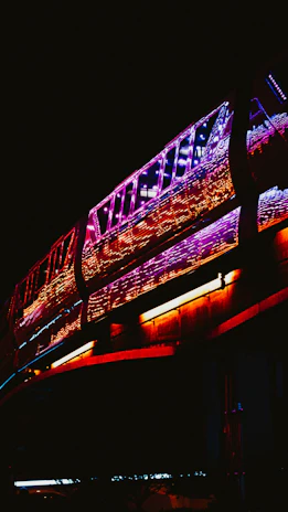 Digital art of trains weaving through a glowing network of vibrant, colorful pathways.