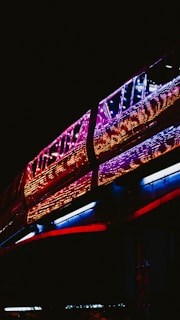 A sleek modern train gliding through a bustling cityscape at dusk, lights reflecting off the rails.