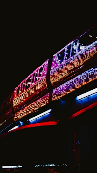 A sleek, futuristic train gliding through a vibrant cityscape at dusk.