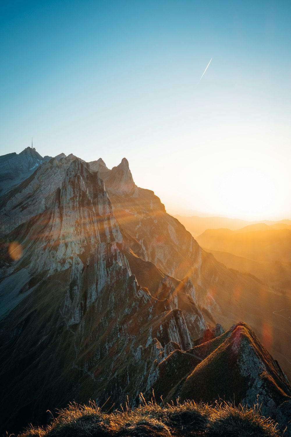 the sun is setting over a mountain range