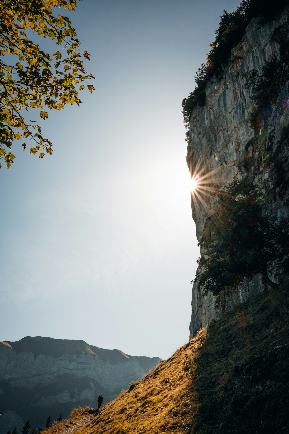 the sun shines brightly over a rocky cliff
