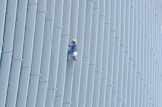 Technician performing high-rise window cleaning using rope access equipment