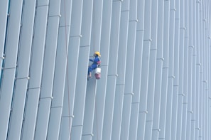 Team member inspecting and repairing commercial building plumbing with safety gear