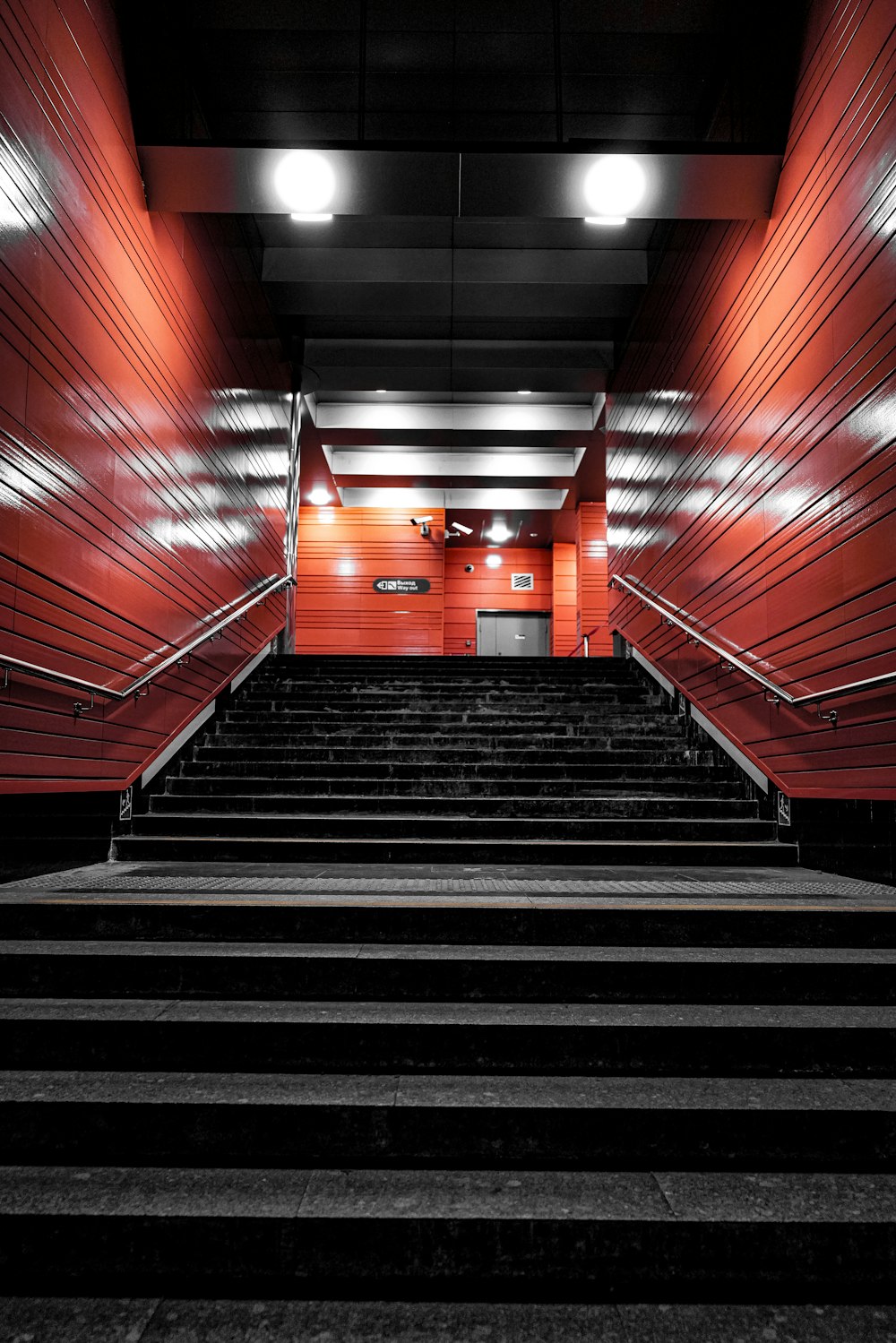 a set of stairs leading up to a red wall