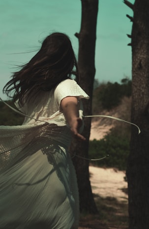 A vibrant photo of a flowing white dress from essência wear, captured mid-movement in a sunlit park.