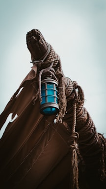 A ship light with weathered metal finish mounted on a wooden surface.