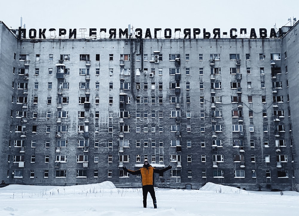 a man standing in front of a tall building