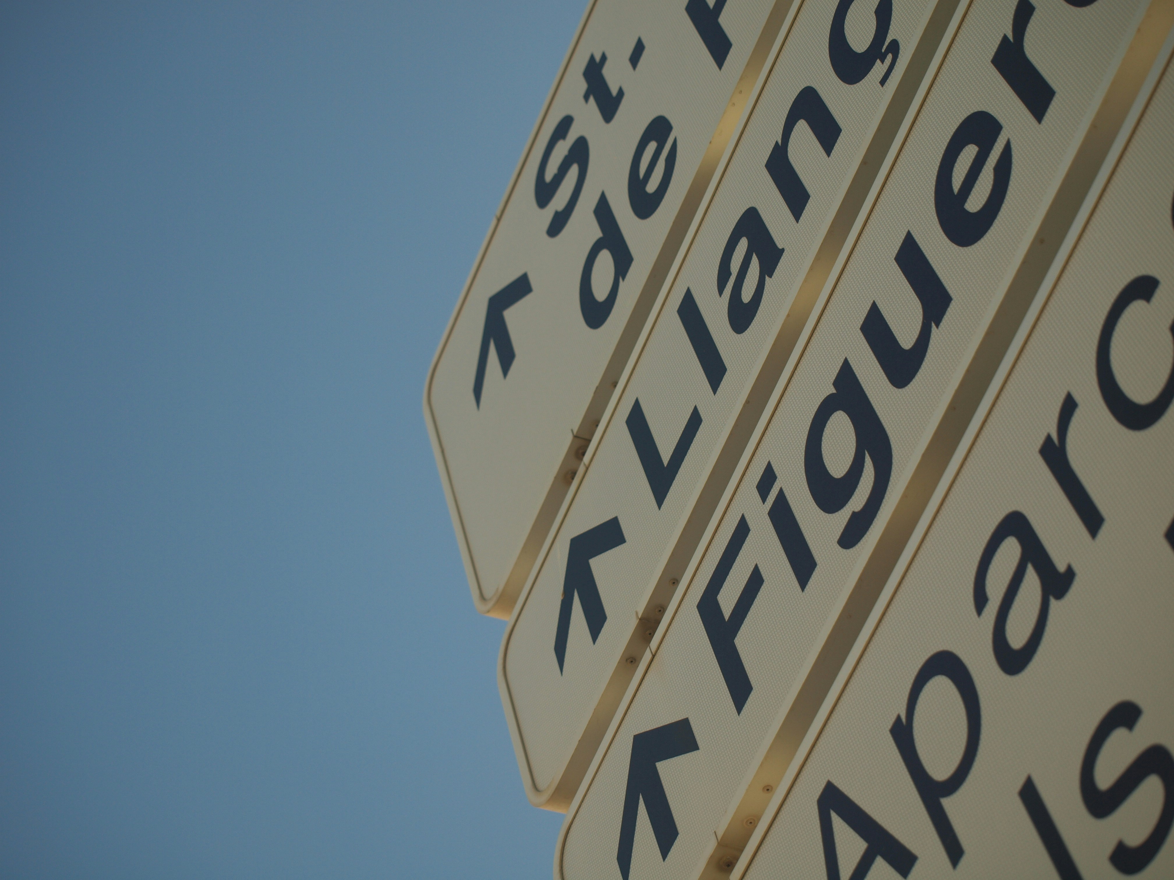 a close up of a street sign with a sky background