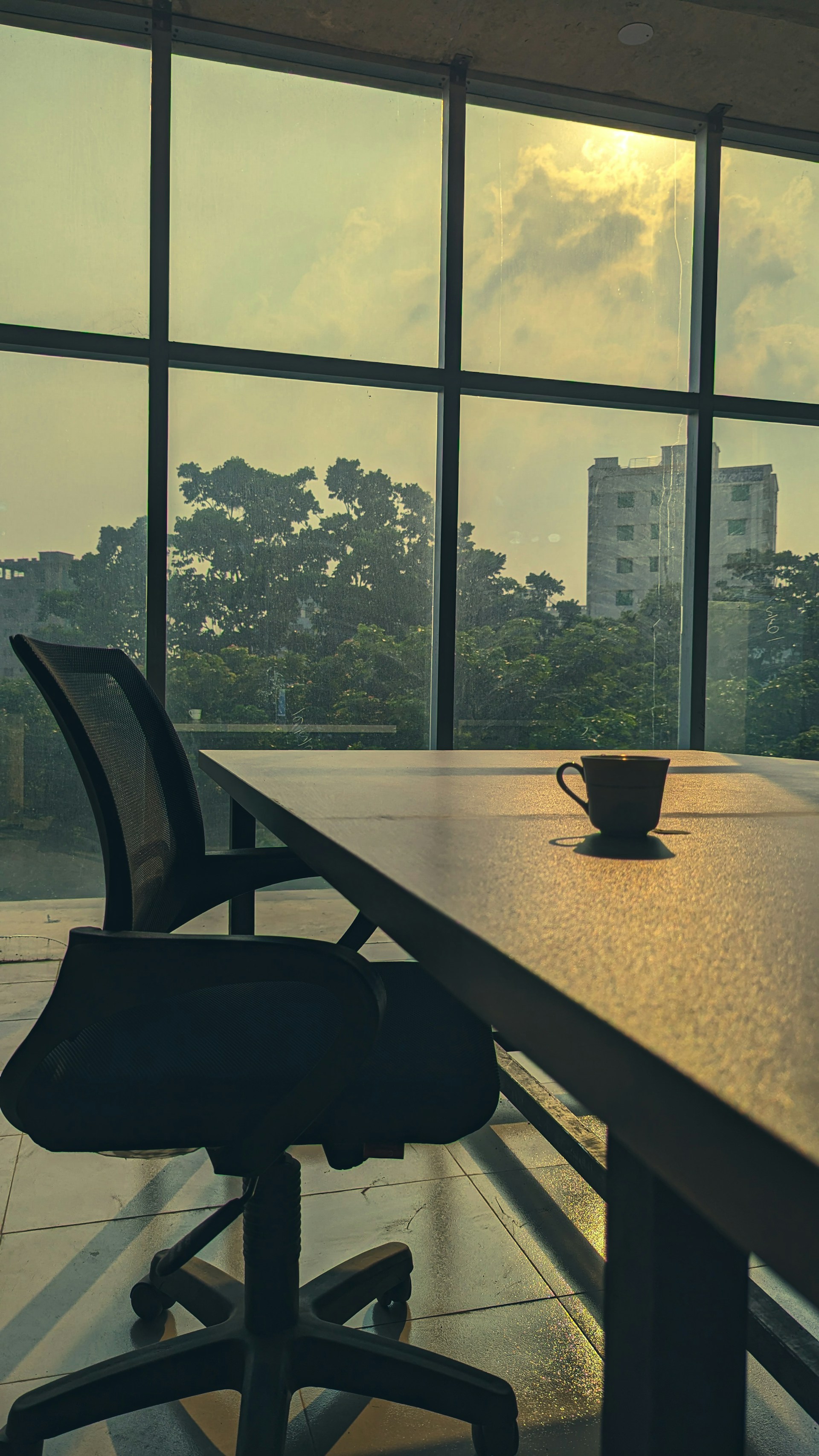 a table with a cup on it in front of a window