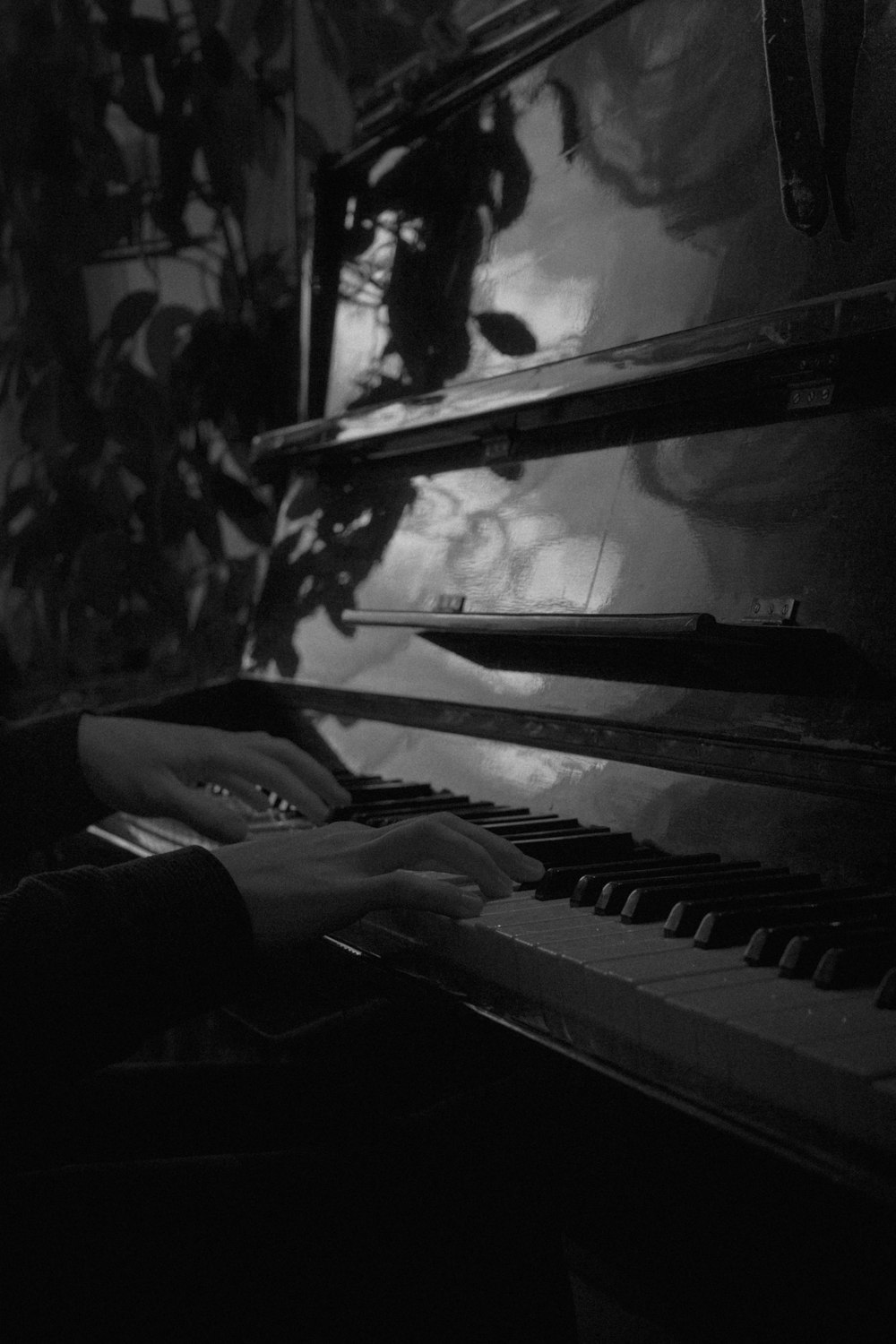 una persona tocando un piano en una habitación oscura