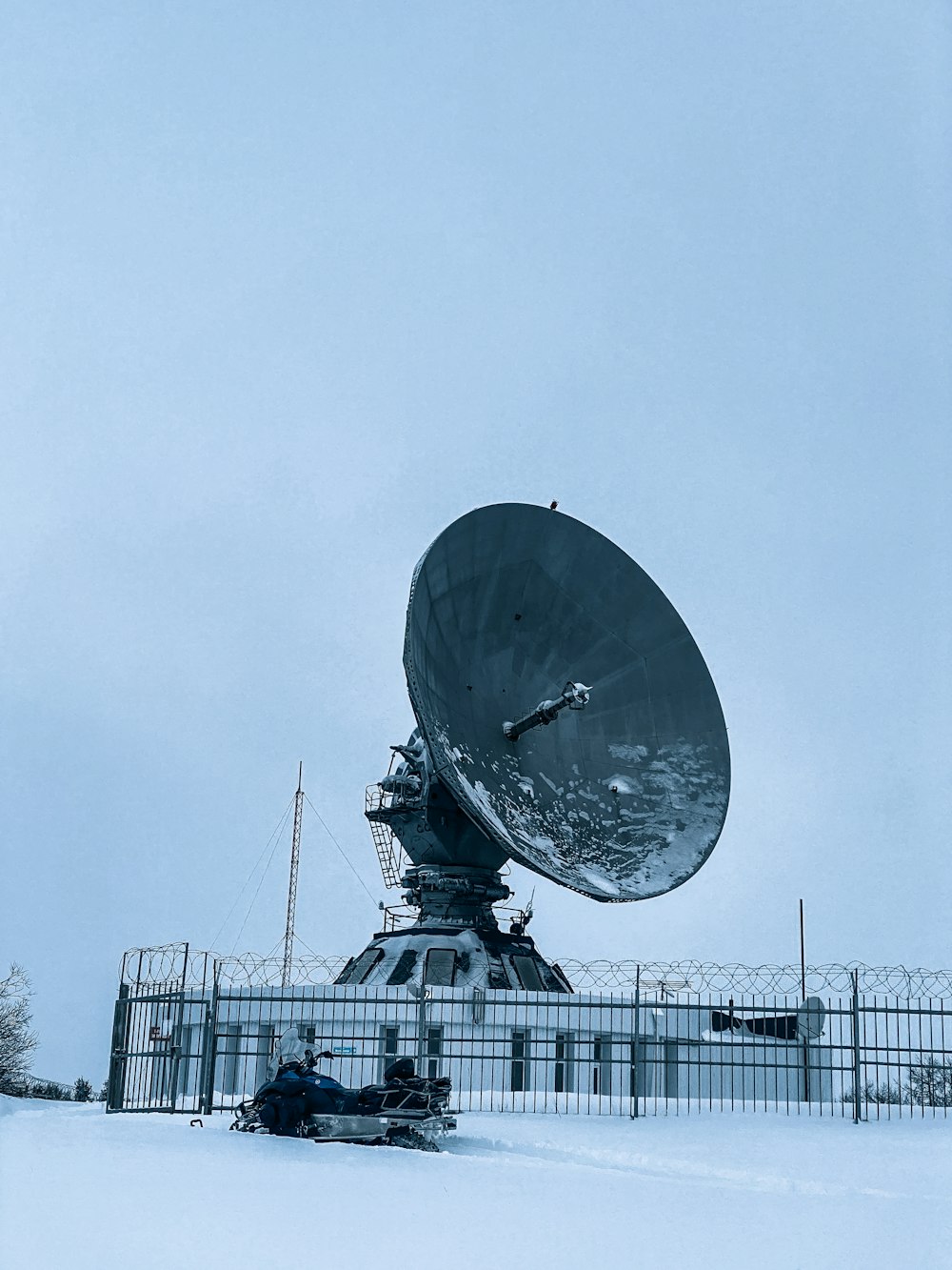 a satellite dish sitting on top of a snow covered field