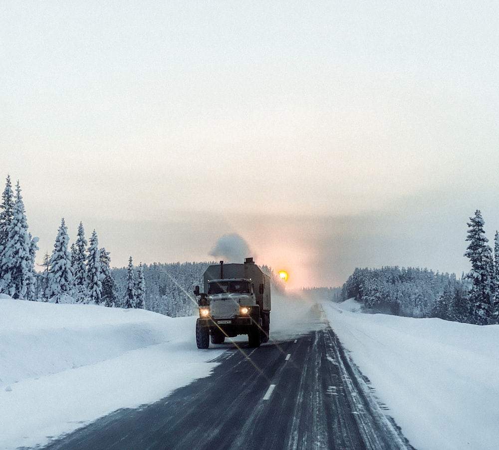 Ein großer Lastwagen, der eine schneebedeckte Straße entlangfährt