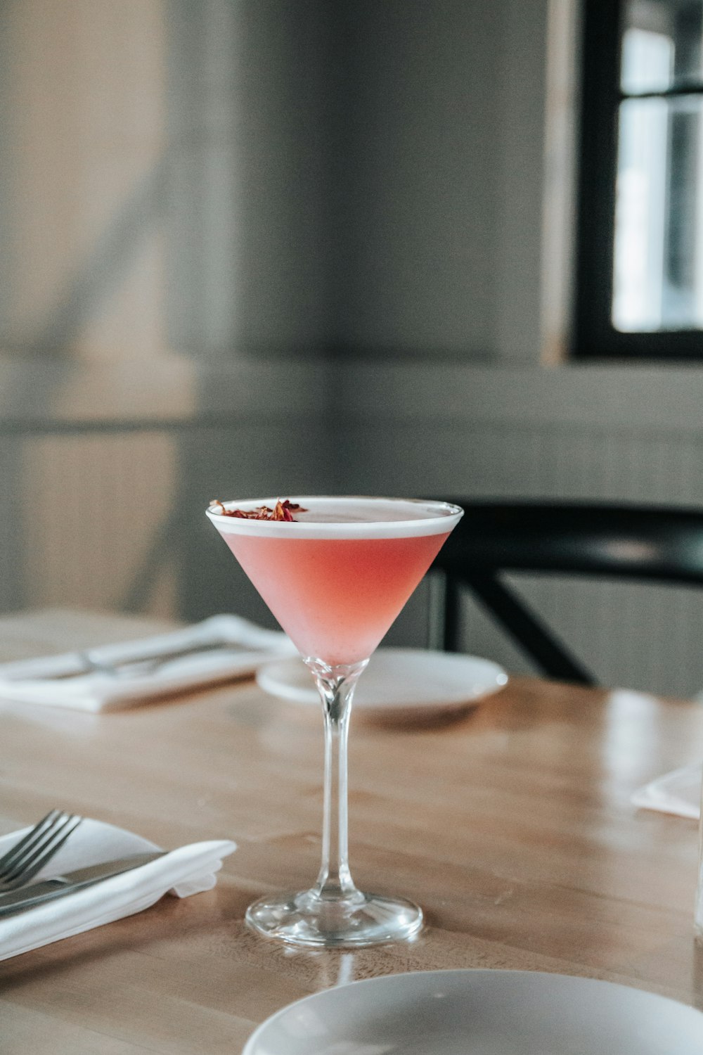 a pink drink sitting on top of a wooden table