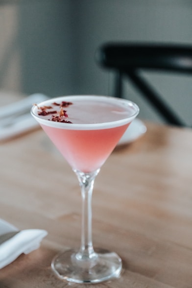 a pink drink sitting on top of a wooden table