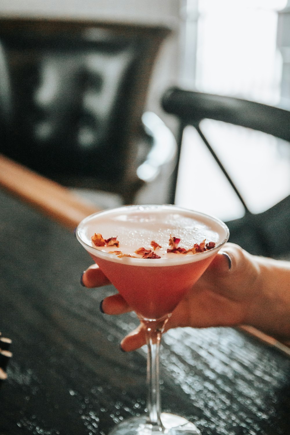 a person holding a drink on a table